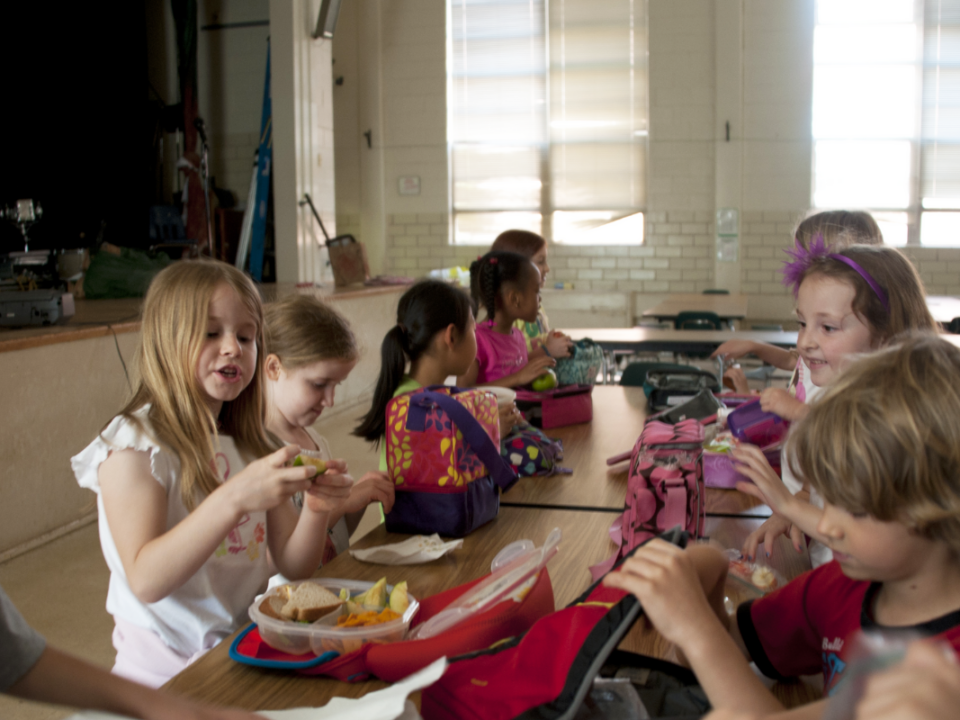 An image of children eating lunch at the school table